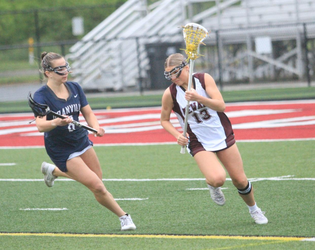 Newark's Madi Johnson takes the ball out of the defensive end against Granville's Lucy Walters during the visiting Blue Aces' 17-2 victory at White Field on Thursday, May 9, 2024.