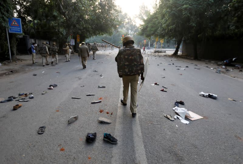 Shoes of demonstrators are seen scattered along the road as police patrol after a protest against a new citizenship law, in New Delhi