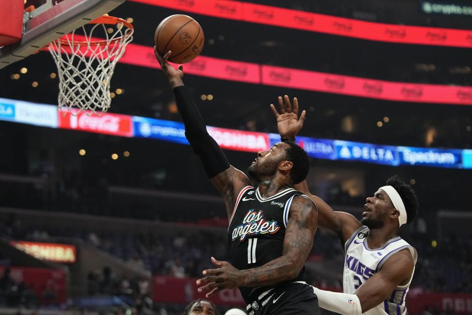 Los Angeles Clippers guard John Wall, left shoots as Sacramento Kings guard Terence Davis defends during the first half of an NBA basketball game Saturday, Dec. 3, 2022, in Los Angeles. (AP Photo/Mark J. Terrill)