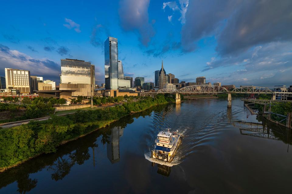 Tugboat goes up the Cumberland River and Nashville Skyline at Sunrise.