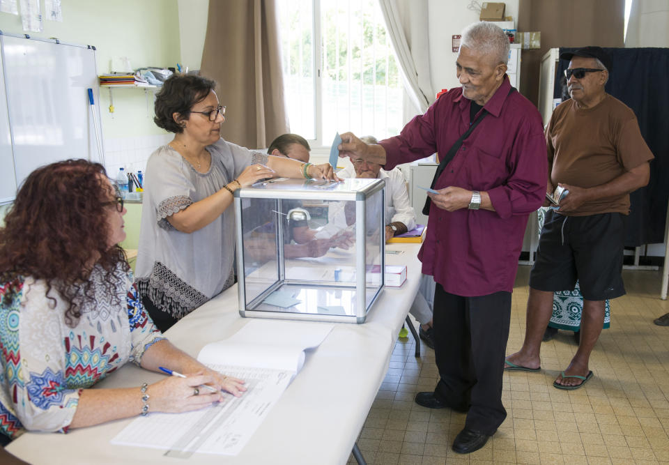 A resident of New Caledonia's capital, Noumea, casts his vote at a polling station as part of an independence referendum, Sunday, Nov. 4, 2018. Voters in New Caledonia are deciding whether the French territory in the South Pacific should break free from the European country that claimed it in the mid-19th century. (AP Photo/Mathurin Derel)