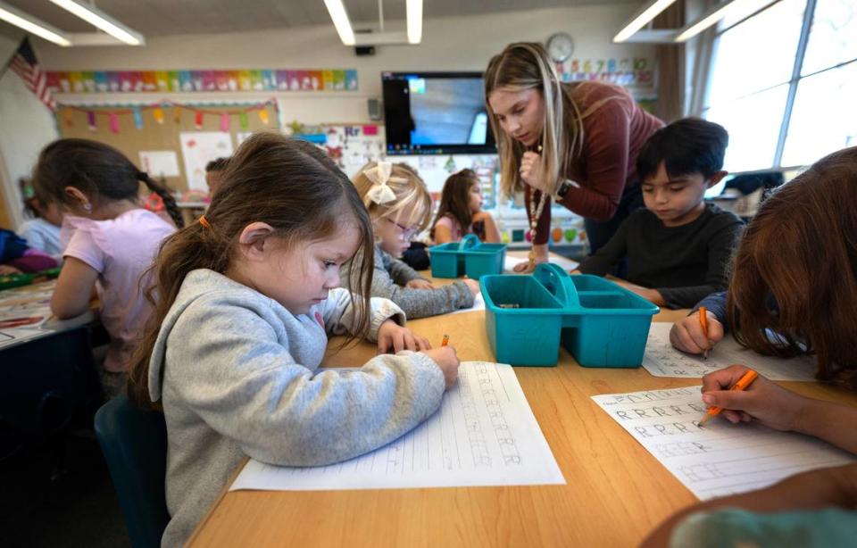 Transitional kindergarten student Vivienne Villarreal, left, and her classmates practice handwriting at Fremont School in Modesto , Calif., Thursday, Dec. 7, 2023. The kindergarten students are working on motors skills and letter recognition to prepare them for cursive writing in later grades. In October, Gov. Gavin Newsom signed a law requiring cursive handwriting instruction mandatory in first through sixth grades effective Jan. 1. Andy Alfaro/aalfaro@modbee.com