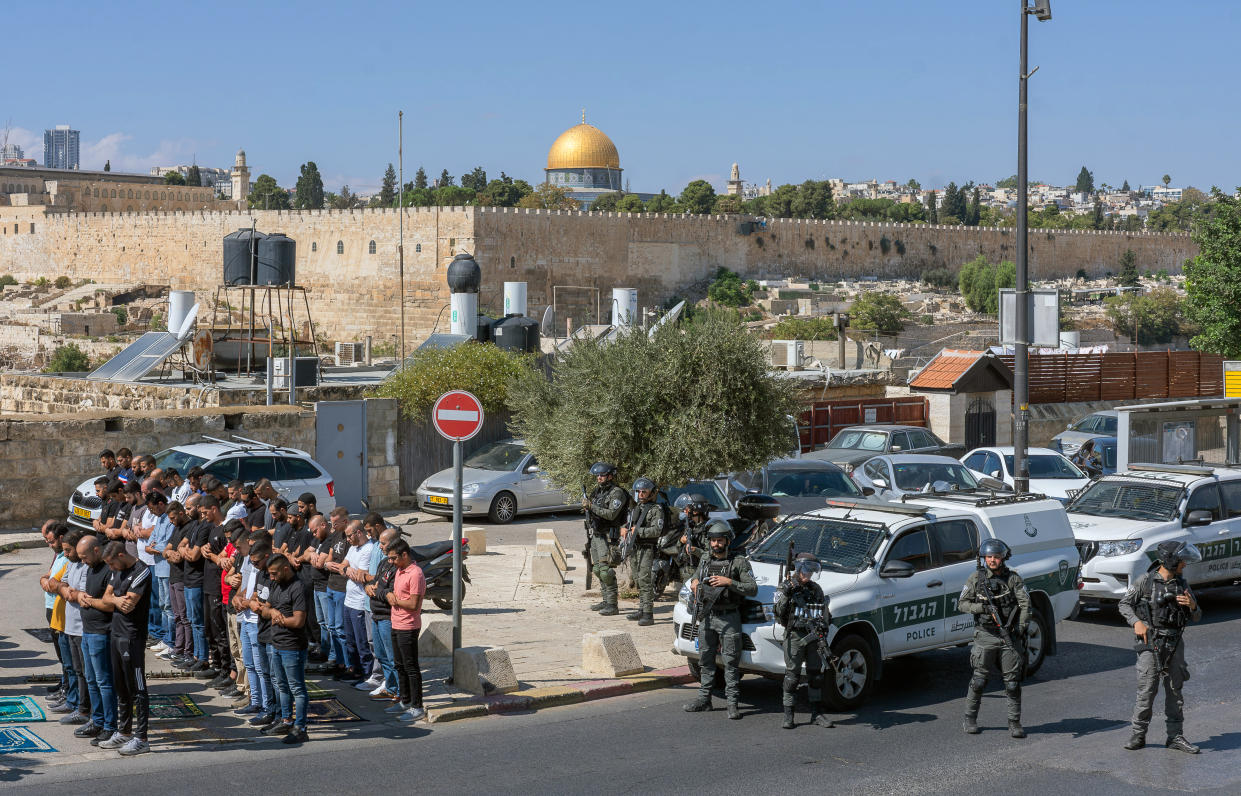 Las Fuerzas de Seguridad de Israel observan mientras los palestinos rezan en Jerusalén, el 13 de octubre de 2023. Cerca de ahí hay un sitio sagrado tanto para los judíos como para los musulmanes que durante años ha sido un foco de tensiones.  (Afif H. Amireh/The New York Times)