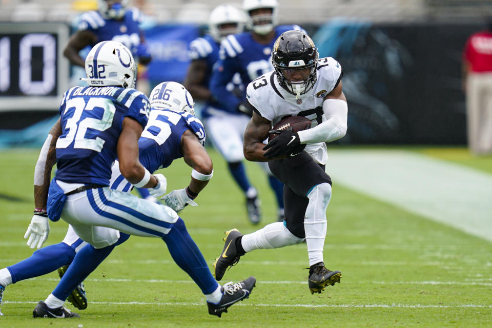 Jacksonville Jaguars wide receiver Christian Kirk (13) tries to get past Indianapolis Colts safeties Julian Blackmon (32) and Rodney McLeod (26) during the first half of an NFL football game, Sunday, Sept. 18, 2022, in Jacksonville, Fla. (AP Photo/John Raoux)