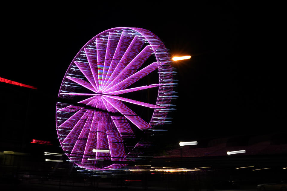 A ferris wheel glows in the evening near downtown in St. Louis on Wednesday, May 19, 2021. (AP Photo/Brynn Anderson)