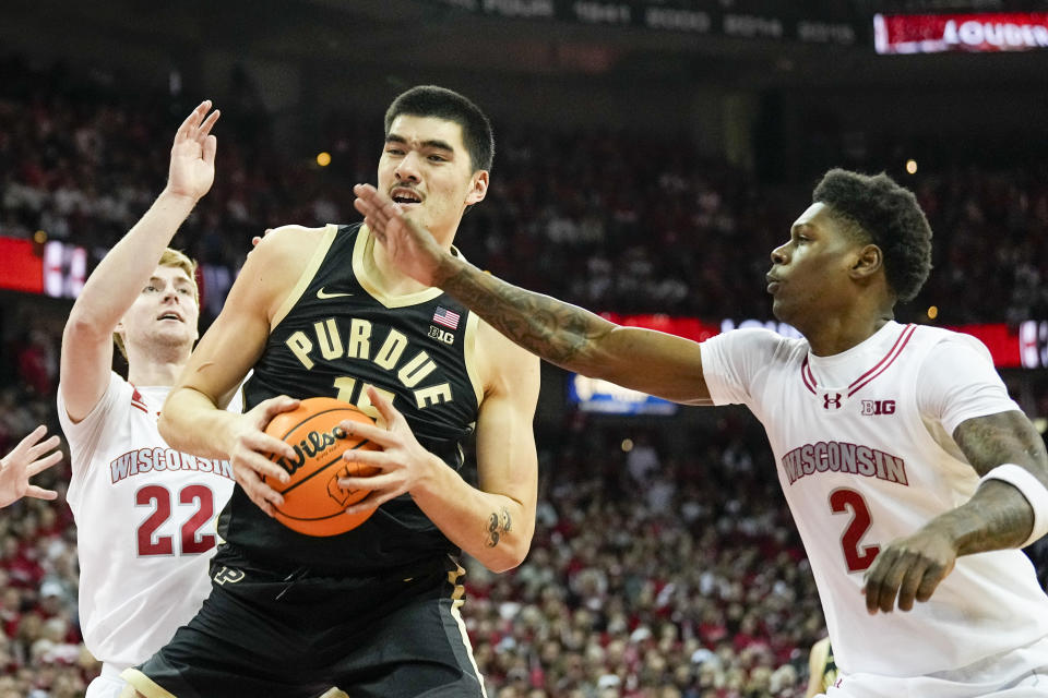 Purdue's Zach Edey (15) battles between Wisconsin's Steven Crowl (22) and AJ Storr, right, during the first half of an NCAA college basketball game Sunday, Feb. 4, 2024, in Madison, Wis. (AP Photo/Andy Manis)