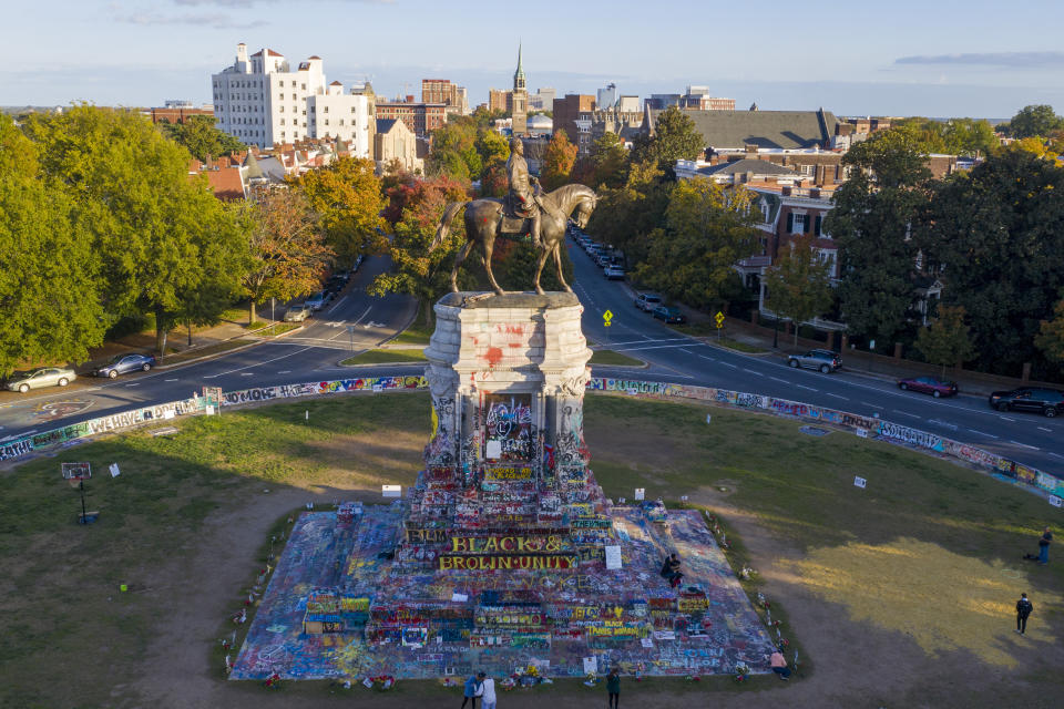 The afternoon sun illuminates the statue of Confederate General Robert E. Lee on Monument Ave in Richmond, Va., Monday, Oct. 19, 2020. A Richmond judge heard arguments in a lawsuit over the Governors' order to remove the statue. (AP Photo/Steve Helber)