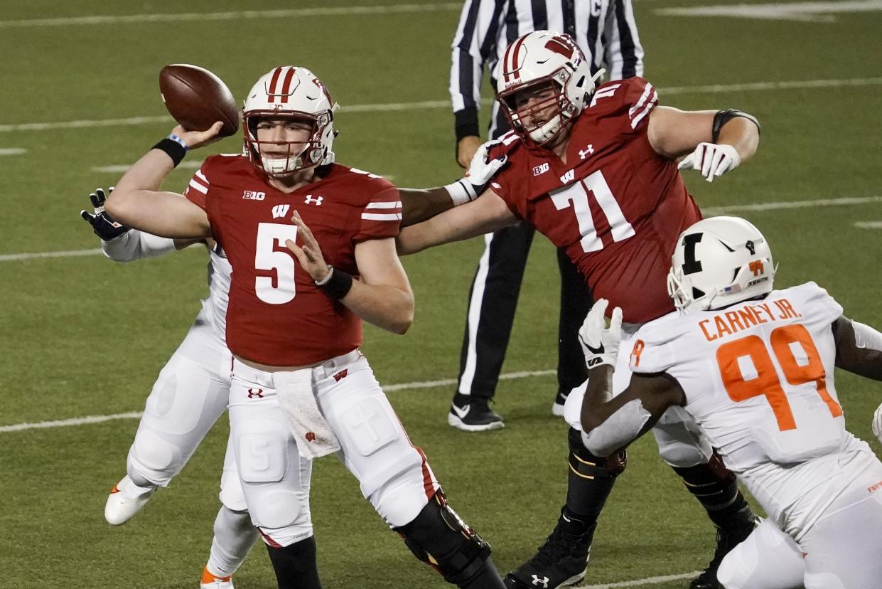 Wisconsin quarterback Graham Mertz throws a pass during the first half of an NCAA college football game against Illinois Friday, Oct. 23, 2020, in Madison, Wis. (AP Photo/Morry Gash)