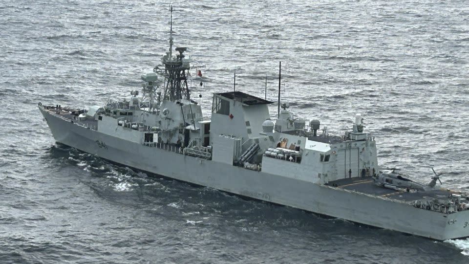 The Canadian frigate HMCS Ottawa is seen from the ship's helicopter as a US Navy helicopter rests on its flight deck in the East China Sea. - Brad Lendon/CNN