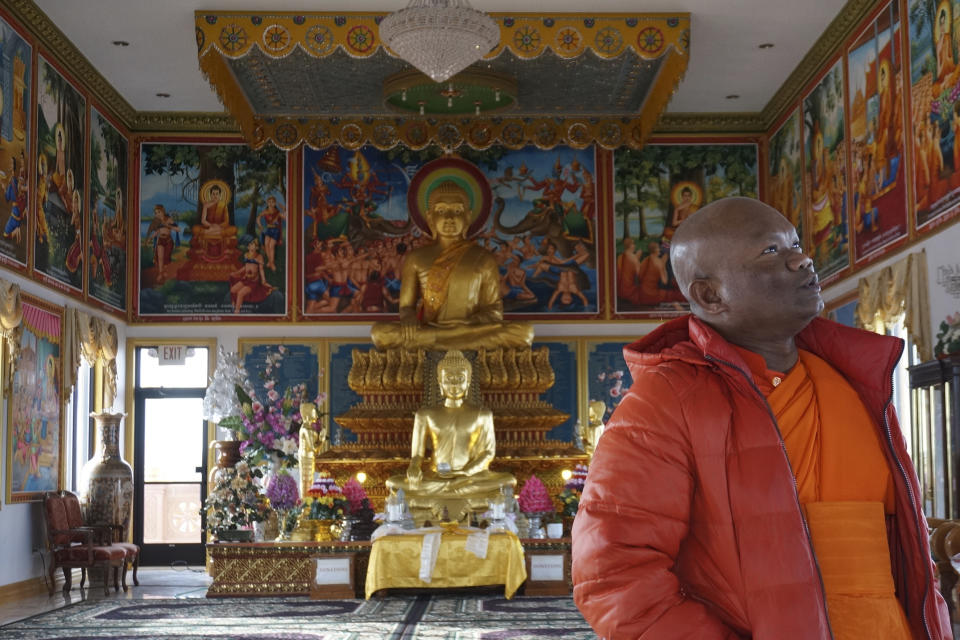 El venerable Vicheth Chum observa las grandes pinturas hechas en Camboya de la vida de Buda en la sala superior del templo Watt Munisotaram, el sábado 4 de febrero de 2023, en Hampton, Minnesota. (AP Foto/Giovanna Dell'Orto)