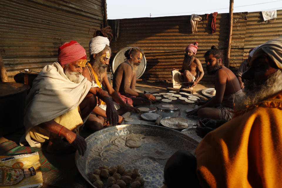 Hindu Holy men prepare food on the banks of the river Ganges during Magh Mela festival, in Prayagraj, India, Tuesday, Feb. 16, 2021. Millions of people have joined a 45-day long Hindu bathing festival in this northern Indian city, where devotees take a holy dip at Sangam, the sacred confluence of the rivers Ganga, Yamuna and the mythical Saraswati. Here, they bathe on certain days considered to be auspicious in the belief that they be cleansed of all sins. (AP Photo/Rajesh Kumar Singh)