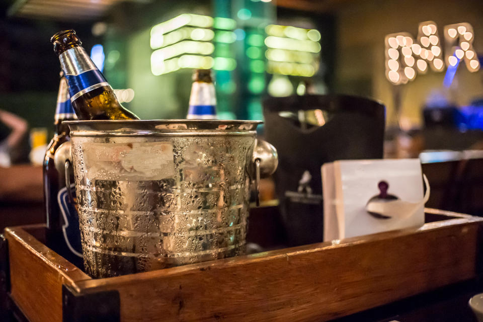 ice bucket of cold bottles beer In the bar and restaurant setting .