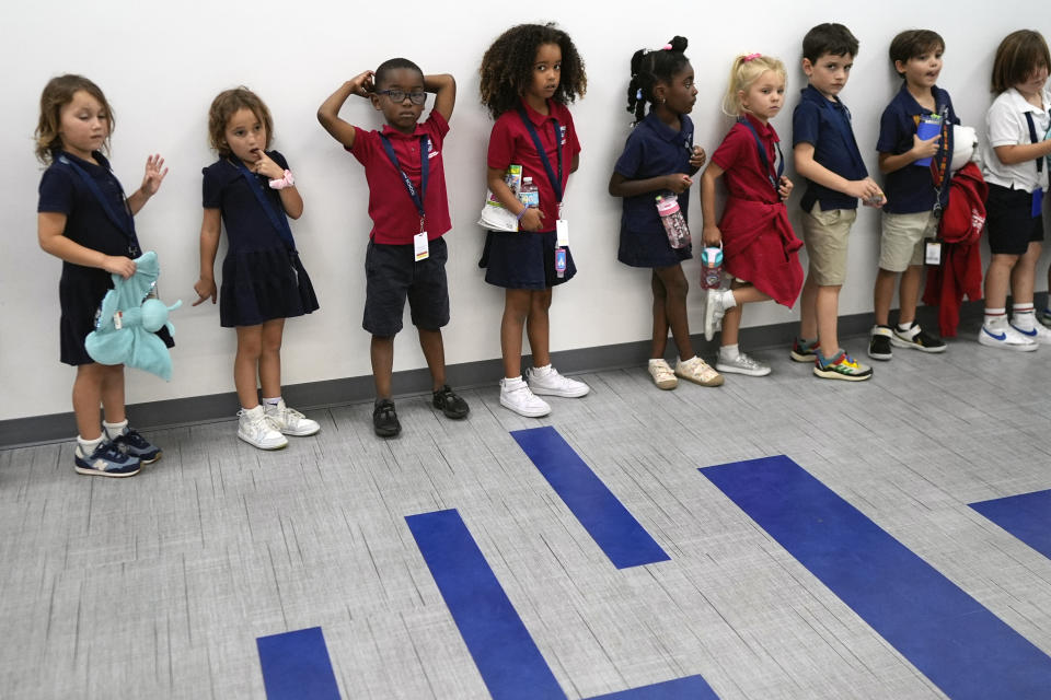 Elementary school students line up in a hall on their way to a class at A.D. Henderson School in Boca Raton, Fla., Tuesday, April 16, 2024. (AP Photo/Rebecca Blackwell)