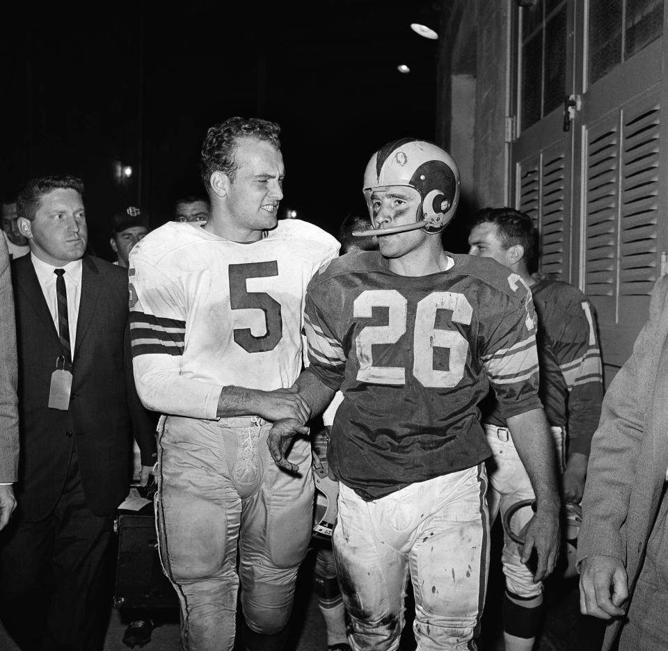 FILE - In this Dec. 17, 1960, file photo, halfback Paul Hornung, left, one of the stars of Green Bay's 35-21 victory over the Los Angeles Rams in the Los Angeles Memorial Coliseum, offers a word of consolation to Ram's halfback Jon Arnett after the game in Los Angeles. Hall of Fame halfback Jon Arnett, one of University of Southern California's greatest running backs who then starred with the Los Angeles Rams, died on Saturday, Jan. 16, 2021, of heart failure in Lake Oswego, Ore. He was 85. (AP Photo/Harold Matosian, File)