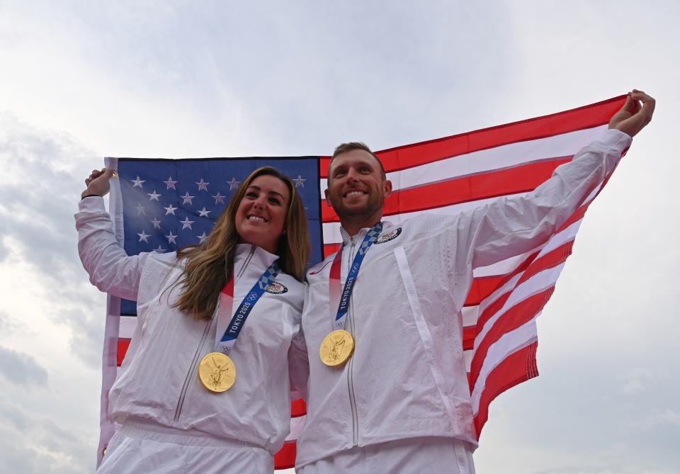 <p>USA's Amber English (L) and USA's Vincent Hancock pose with their gold medals and national flag on the podium after in the skeet finals during the Tokyo 2020 Olympic Games at the Asaka Shooting Range in the Nerima district of Tokyo on July 26, 2021. (Photo by Tauseef MUSTAFA / AFP) (Photo by TAUSEEF MUSTAFA/AFP via Getty Images)</p> 