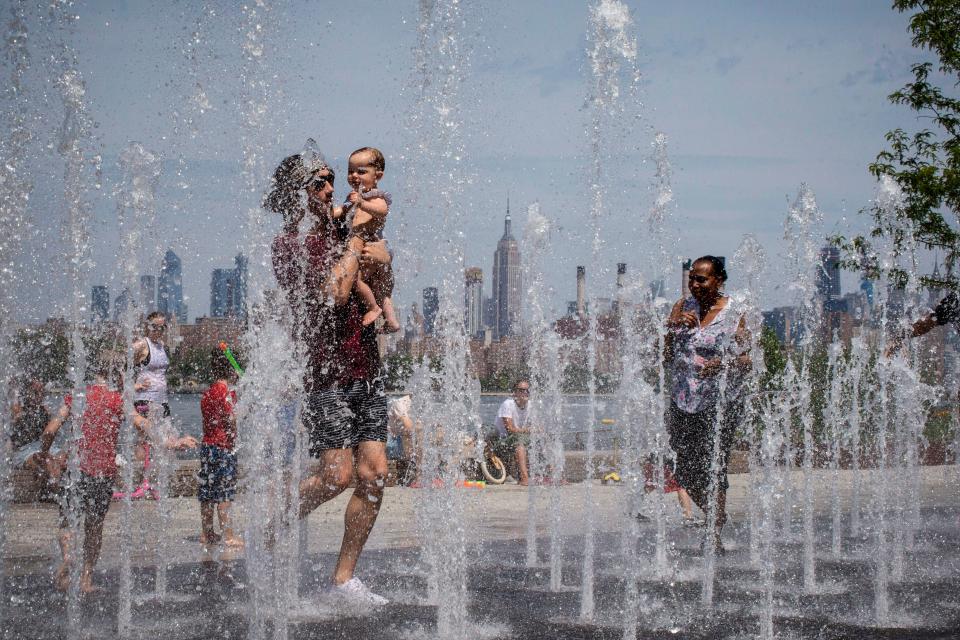 FILE - This photo from Saturday July 20, 2019, shows people playing in a water fountain at the Empire State Building in the Williamsburg section of Brooklyn, N.Y. State regulators have been working to require public water systems to test for and clean up three contaminants linked with long-term health risks such as severe kidney and liver damage.