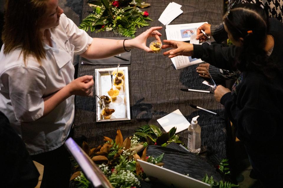 A worker for Sawyer’s Catering hands a sample to an attendee during the Jackson Bridal Show at the Carl Perkins Civic Center on Sunday, January 8, 2023, in Jackson, Tenn. 