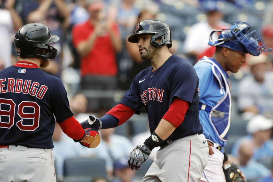 Boston Red Sox' J.D. Martinez, center, is congratulated by Alex Verdugo, left, after hitting a two-run home run as Kansas City Royals catcher Salvador Perez, right, looks away in the fifth inning of a baseball game at Kauffman Stadium in Kansas City, Mo., Saturday, June 19, 2021. (AP Photo/Colin E. Braley)