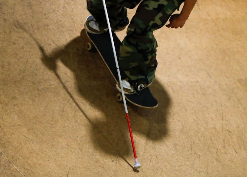 Blind Japanese skateboarder Ryusei Ouchi trains at a skatepark holding a cane, in Tokorozawa