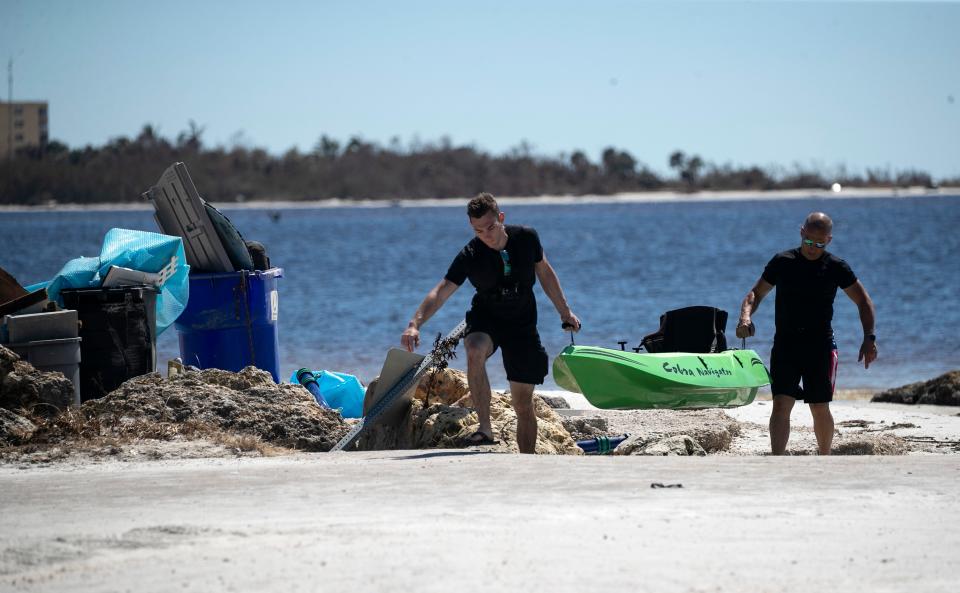 Jeff Weigel, right, and his son Noah return their kayak to their car after kayaking from Bunche Beach just north of Fort Myers Beach  to Sanibel Island and back to check on their restaurant, The Sanibel Deli, on Monday, Oct. 3, 2022.