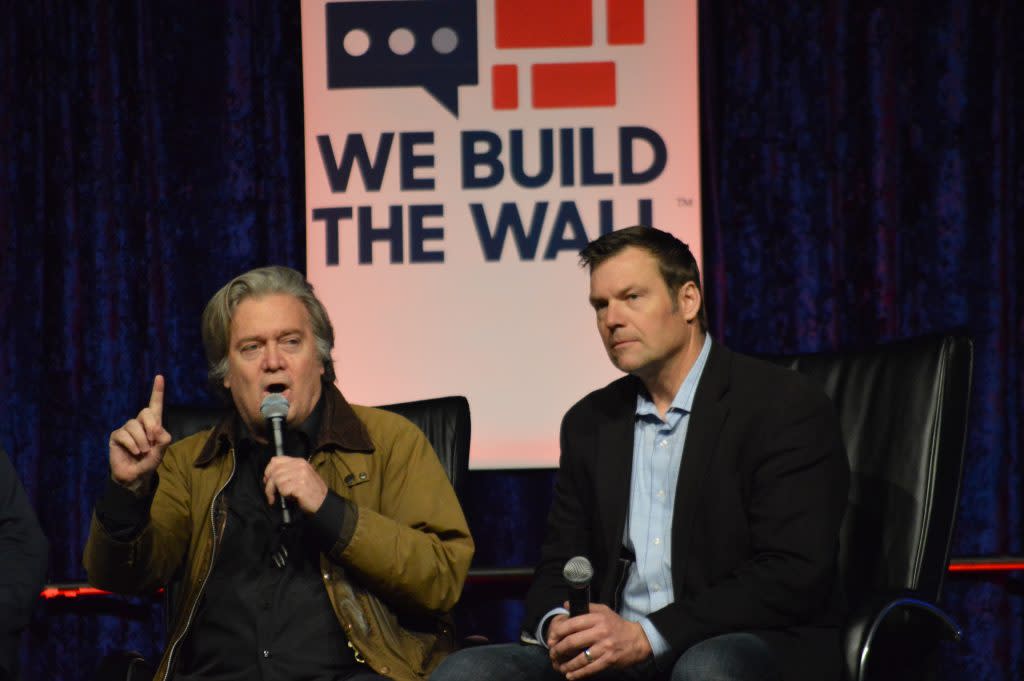 Steve Bannon and Kris Kobach speak at a “We Build the Wall” event on March 14, 2019, in Cobo, Michigan.