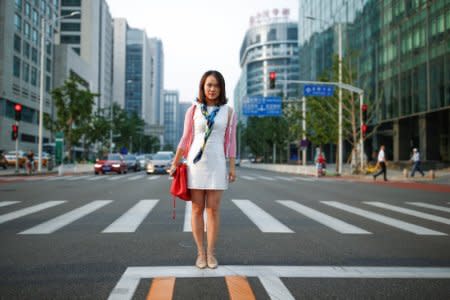 Zhang Weixuan, an assistant secretary of the board at a software company, poses for pictures near her office in Beijing's financial district, China, September 3, 2017.   REUTERS/Thomas Peter