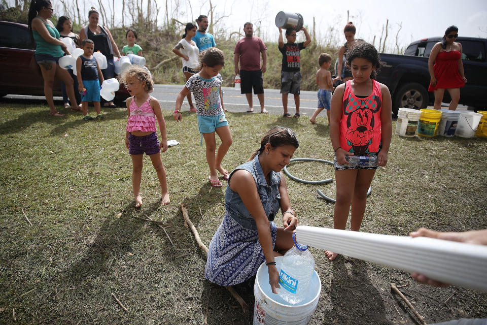People in Corazal, Puerto Rico, fill&nbsp;containers with water from a natural spring on the side of the road as people deal with the aftermath of Hurricane Maria. (Photo: Joe Raedle via Getty Images)