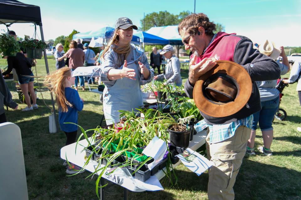 A customer almost loses his hat while inspecting plants at the Randall County Master Gardeners plant sale Saturday as part of Gardenfest at the Texas A&M AgriLife Extension Center in Amarillo.