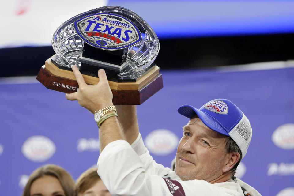 Texas A&M coach Jimbo Fisher holds up the Texas Bowl trophy after the team's 24-21 win over Oklahoma State in the NCAA college football game Friday, Dec. 27, 2019, in Houston. (AP Photo/Michael Wyke)