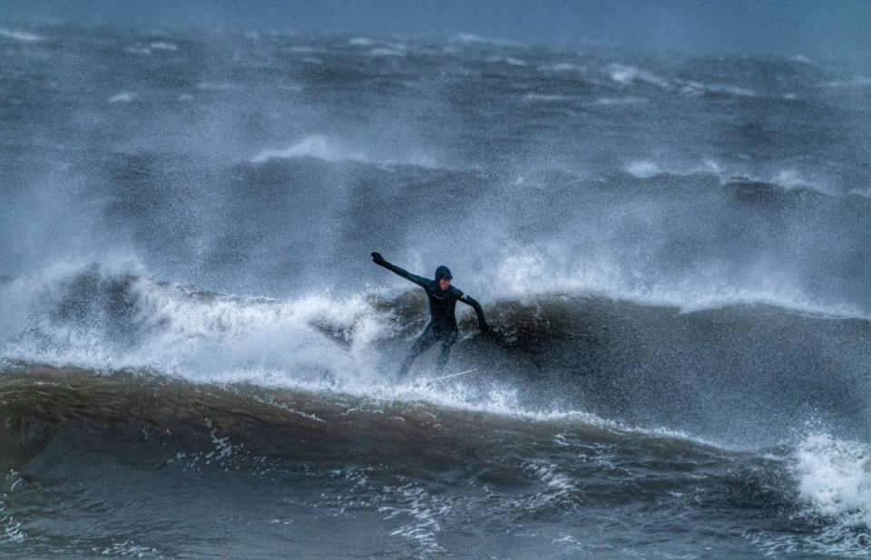 A surfer off the North East coast at Tynemouth (PA)