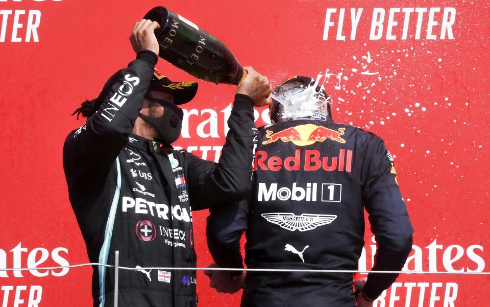 Winner Dutch Formula One driver Max Verstappen of Aston Martin Red Bull Racing (R) and second British Formula One driver Lewis Hamilton of Mercedes-AMG Petronas (L) celebrate on the podium after the 70th Anniversary Formula One Grand Prix of Great Britain at the Silverstone Circuit - SHUTTERSTOCK