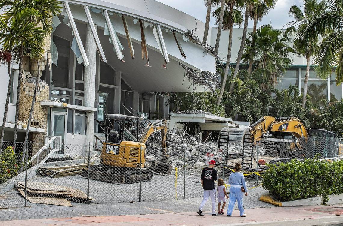 Pedestrians walk by the historic Deauville Beach Resort in Miami Beach on Sunday, March 13, 2022, a day after workers began tearing down the hotel’s porte-cochere and metallic red sign.
