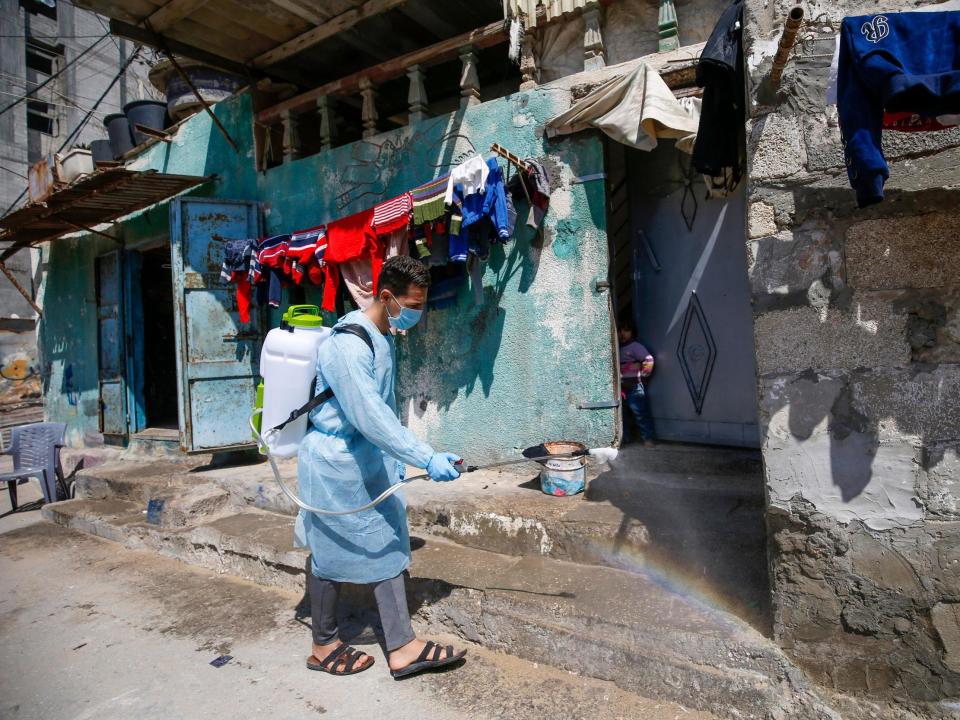 Palestinian volunteers spray disinfectant on a street at al-Shati refugee camp in Gaza City: AFP/Getty