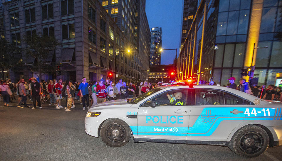 A police cruiser patrols around the Bell Centre, where thousands of Montreal Canadiens fans have assembled for Game 6 of an NHL hockey Stanley Cup semifinal playoff series against the Vegas Golden Knights, in Montreal, Thursday, June 24, 2021. Today is also the provincial holiday of Saint-Jean-Baptiste Day. T(Peter McCabe/The Canadian Press via AP)