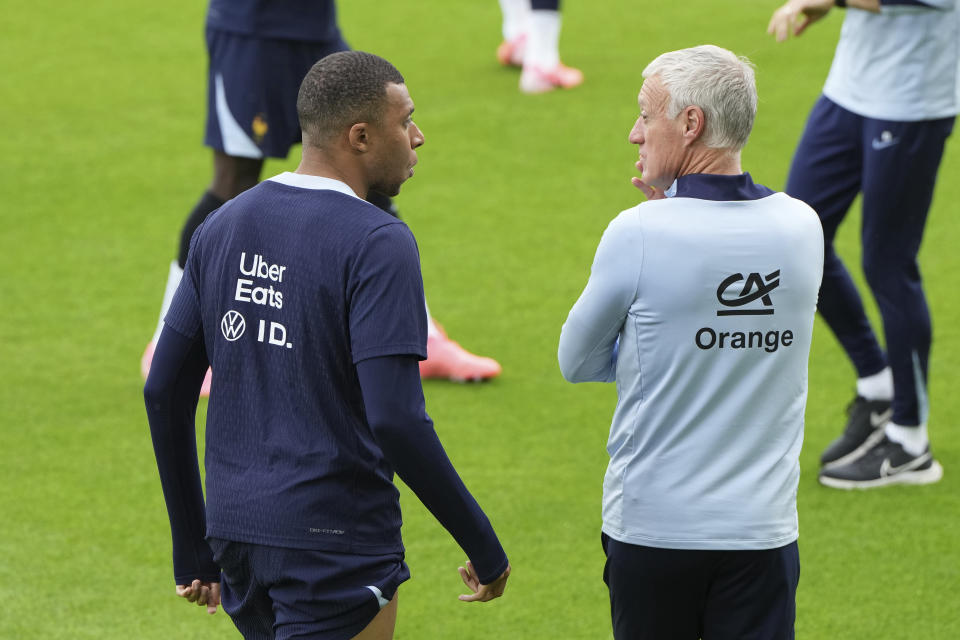 France head coach Didier Deschamps, right, speaks with his player Kylian Mbappe during a training session in Paderborn, Germany, Saturday, June 15, 2024. France will play against Austria during their Group D soccer match at the Euro 2024 soccer tournament on June 17. (AP Photo/Hassan Ammar)