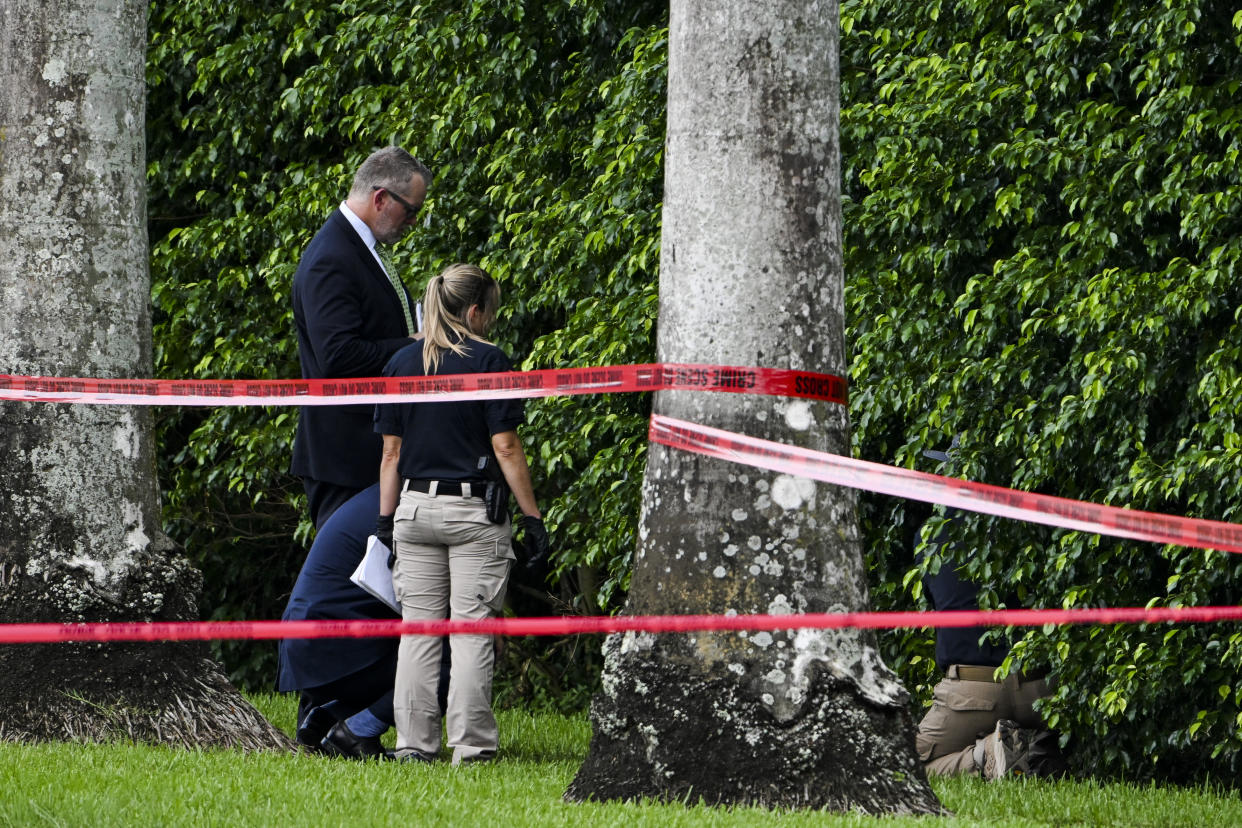 Law enforcement officials work at the crime scene outside the Trump International Golf Club.