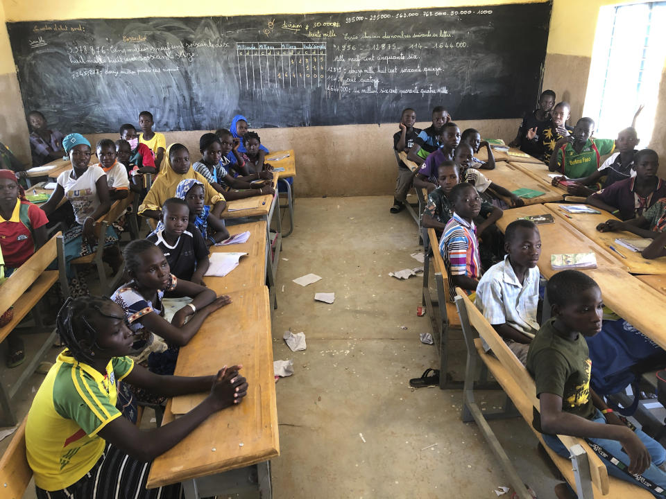 FILE- Children gather in a classroom at school in the village of Dori, Burkina Faso, Tuesday Oct. 20, 2020. More than half of the displaced by growing violence between Islamic extremists and security forces are children, and many are traumatized by their experiences. But mental health services in the West African country are limited, and children are often overlooked for treatment.(AP Photo/Sam Mednick, File)