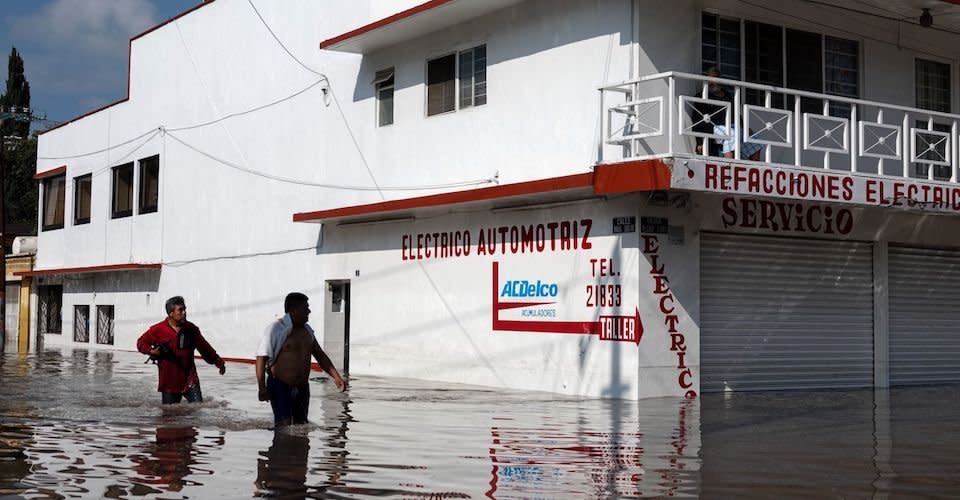 Personas avanzan en las partes bajas de la zona inundada en el centro de Tula, Hidalgo.