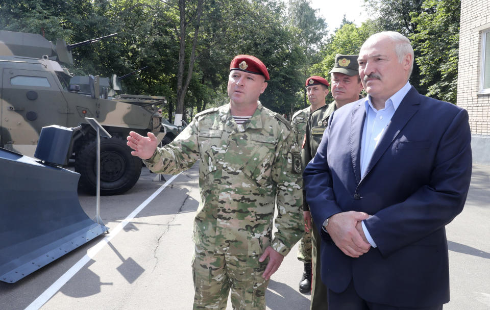 Belarus President Alexander Lukashenko, right, inspects police vehicles as he visits the Belarusian Interior Ministry special forces base in Minsk, Belarus, Tuesday, July 28, 2020. The presidential election in Belarus is scheduled for Aug. 9, 2020. (Nikolai Petrov/BelTA Pool Photo via AP)