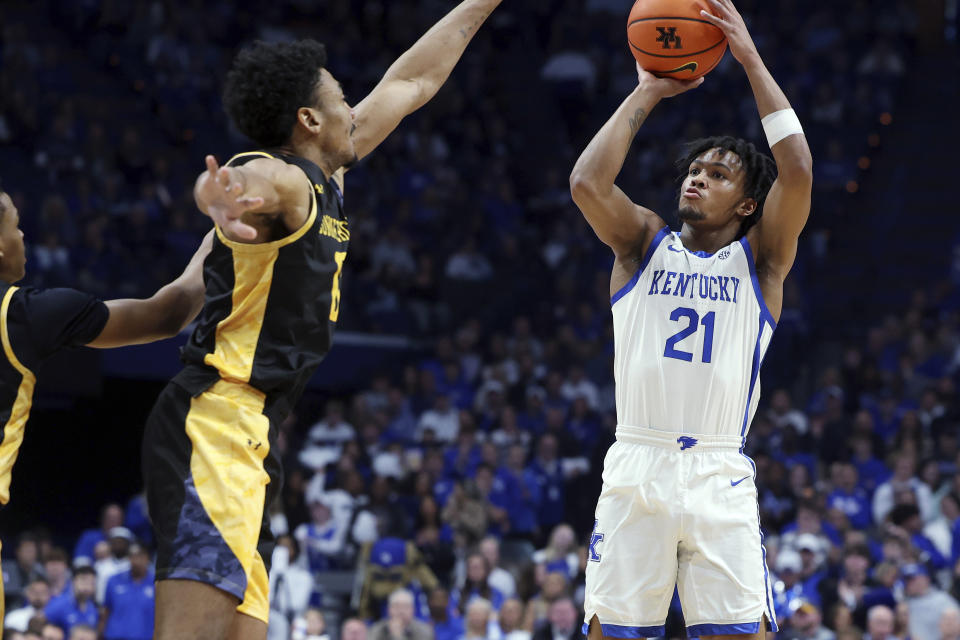 Kentucky's D.J. Wagner (21) shoots near Texas A&M-Commerce's Zondrick Garrett, left, during the first half of an NCAA college basketball game in Lexington, Ky., Friday, Nov. 10, 2023. (AP Photo/James Crisp)