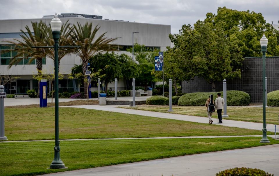 Student walk through a grassy area at Cerritos College.