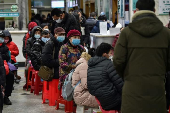 People wearing facemasks queued up to be tested at a hospital in Wuhan (AFP Photo/Hector RETAMAL)