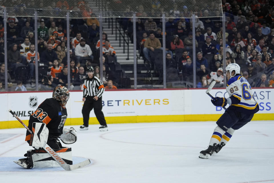 St. Louis Blues' Jake Neighbours, right skates away after scoring on Philadelphia Flyers goaltender Samuel Ersson during a shootout in an NHL hockey game, Monday, March 4, 2024, in Philadelphia. (AP Photo/Matt Rourke)