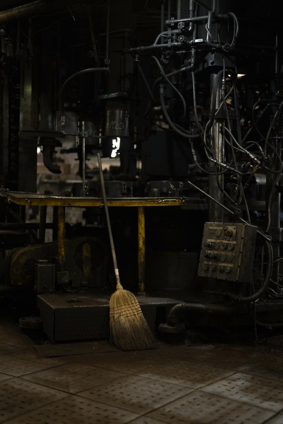 A broom leans against a machine in the factory of the French glassmaker Duralex, in La Chapelle Saint-Mesmin, central France, Wednesday, Sept. 7, 2022. Iconic French tableware brand Duralex is joining a growing array of European firms that are reducing and halting production because of soaring energy costs. (AP Photo/Thibault Camus)