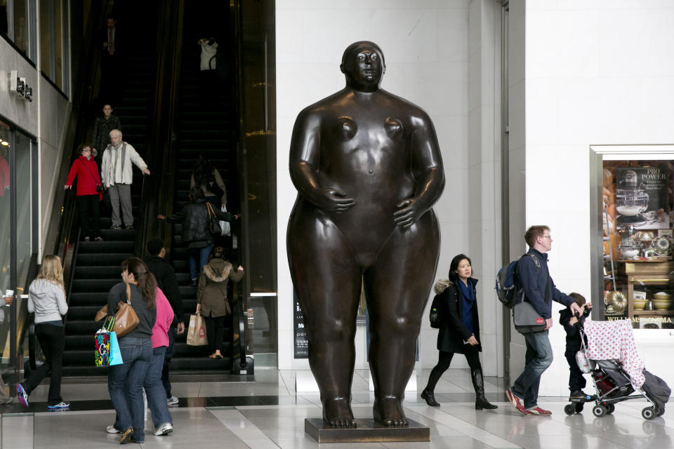 ARCHIVO - Visitantes del Time Warner Center caminan alrededor de la escultura de Fernando Botero titulada Eva en Nueva York, 30 de octubre de 2013. Botero murió el 15 de septiembre de 2023 en Mónaco, según su hija Lina Botero, quien confirmó su fallecimiento a la radio colombiana Caracol. (AP Foto/Mark Lennihan, Archivo)