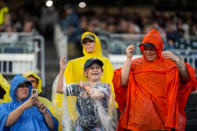 Fans dance in the rain before a rain-delayed baseball game between the Atlanta Braves and the San Diego Padres, Saturday, May 18, 2024, in Atlanta. (AP Photo/Mike Stewart)