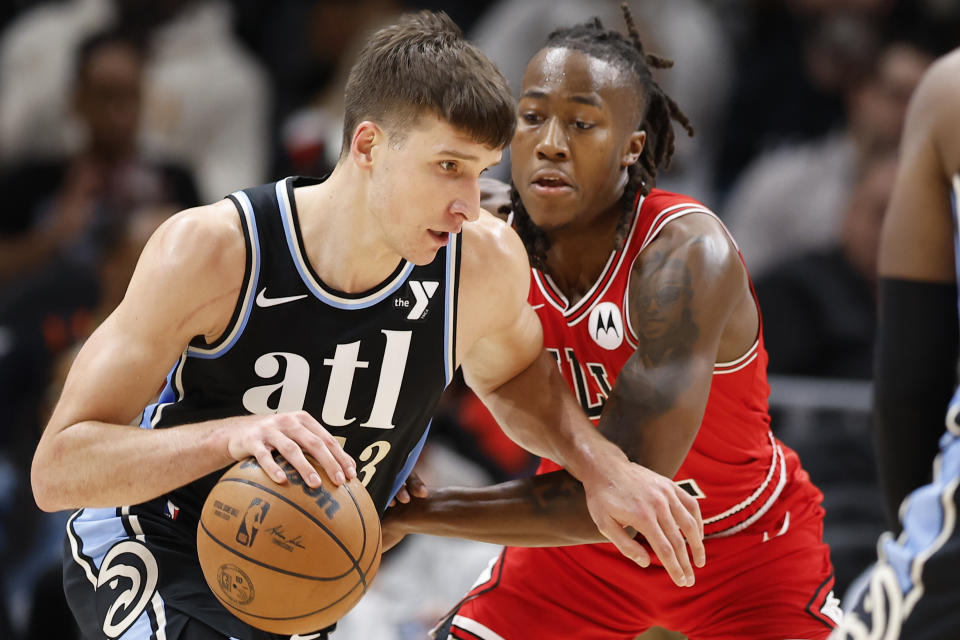 Atlanta Hawks guard Bogdan Bogdanovic, left, works against Chicago Bulls guard Ayo Dosunmu during the first half of an NBA basketball game on Monday, Feb. 12, 2024, in Atlanta. (AP Photo/Alex Slitz)