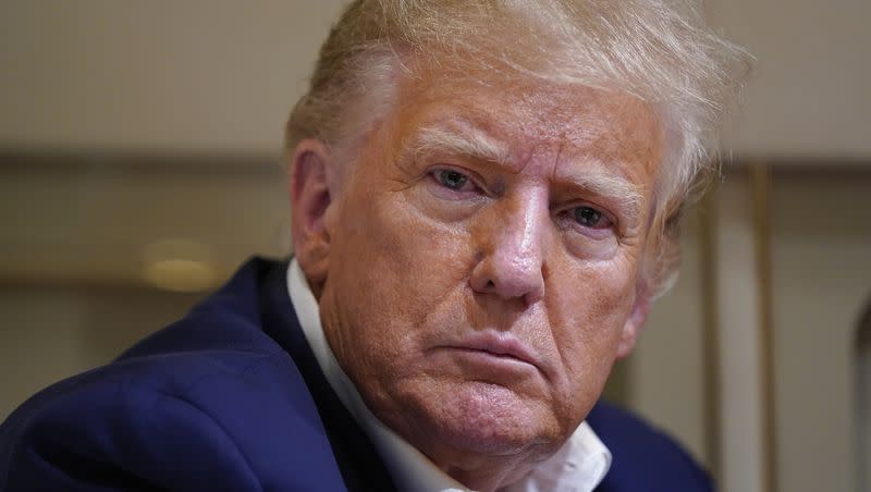 Former President Donald Trump listens as he speaks with reporters while in flight on his plane after a campaign rally at Waco Regional Airport, in Waco, Texas, Saturday, March 25, 2023, while en route to West Palm Beach, Fla.