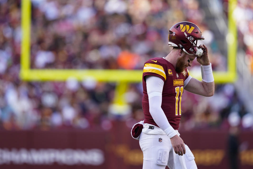 Washington Commanders quarterback Carson Wentz (11) walks to the sideline during a timeout during the first half of an NFL football game against the Cleveland Browns, Sunday, Jan. 1, 2023, in Landover, Md. (AP Photo/Patrick Semansky)