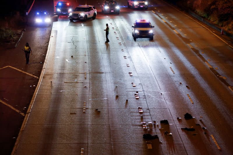 Washington State Troopers investigate the scene where two people in a group of protesters were struck by a car on Interstate 5, in Seattle